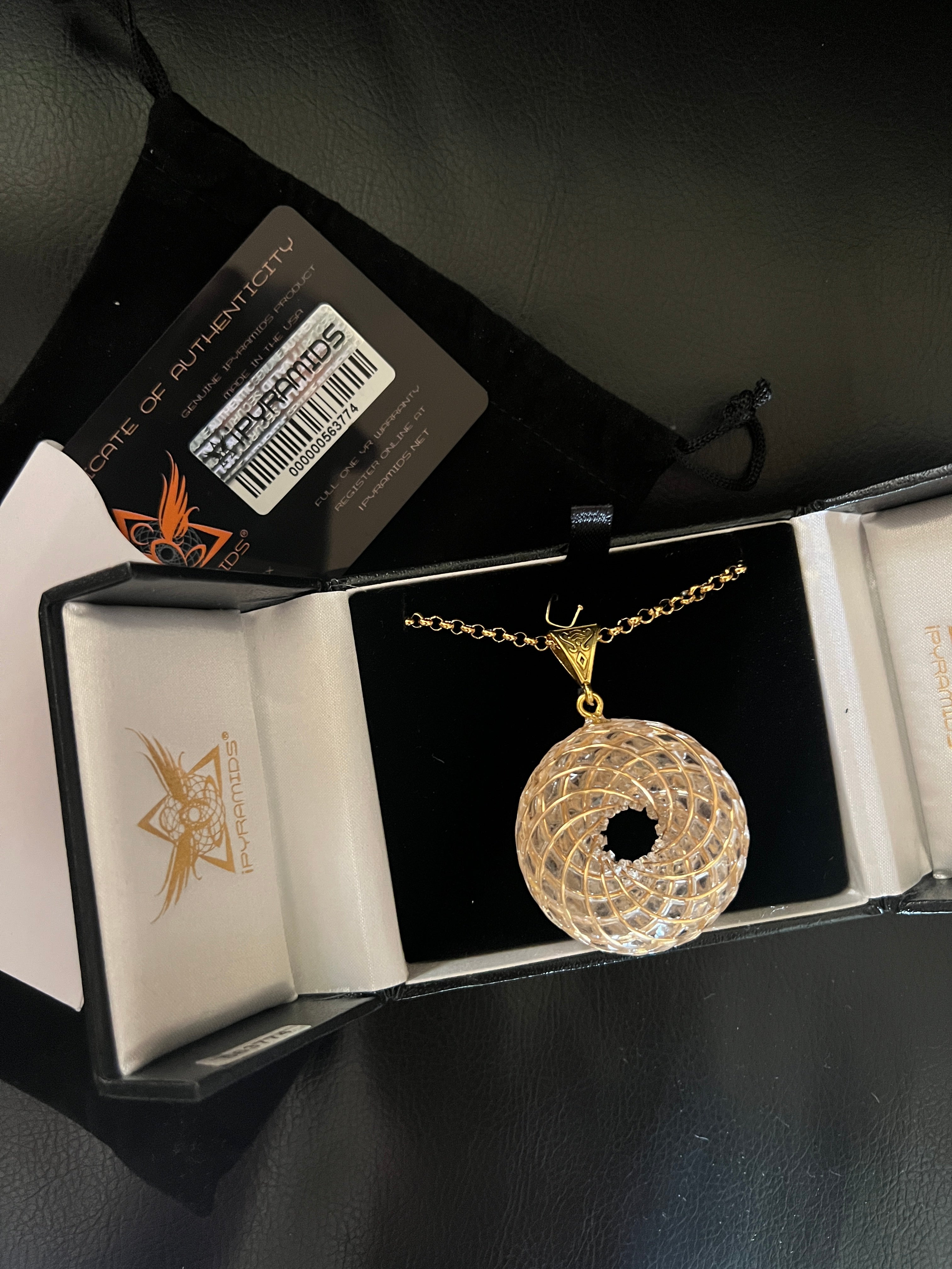 Rainbow Phenakite crystal 18K pendant in gold setting displayed in jewelry box by iPyramids